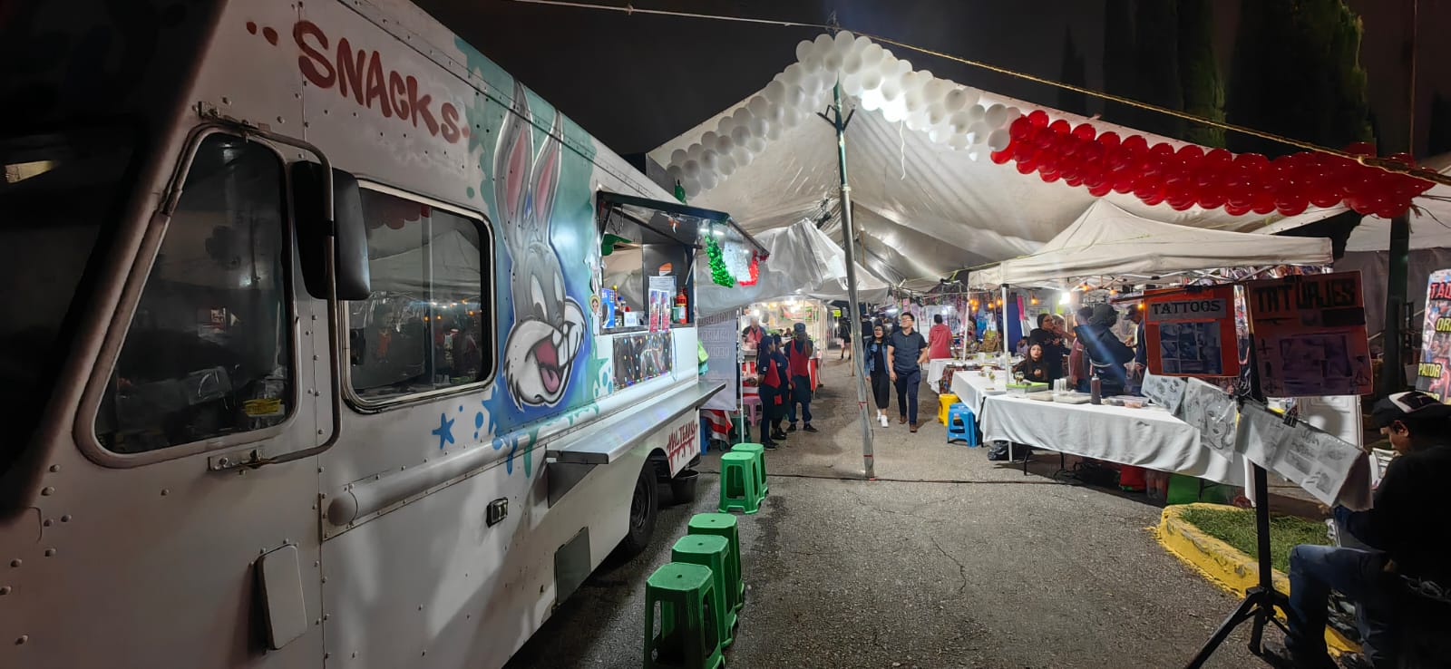Food truck Delitruck en evento nocturno con puestos y luces
